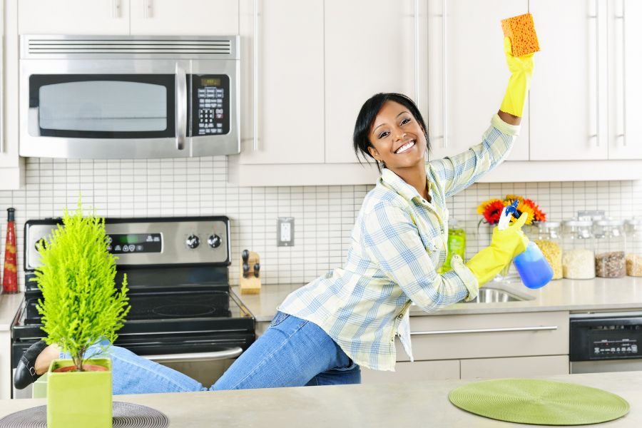 Person happy and smiling while cleaning kitchen