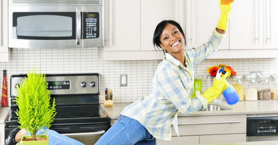 Person happy and smiling while cleaning kitchen